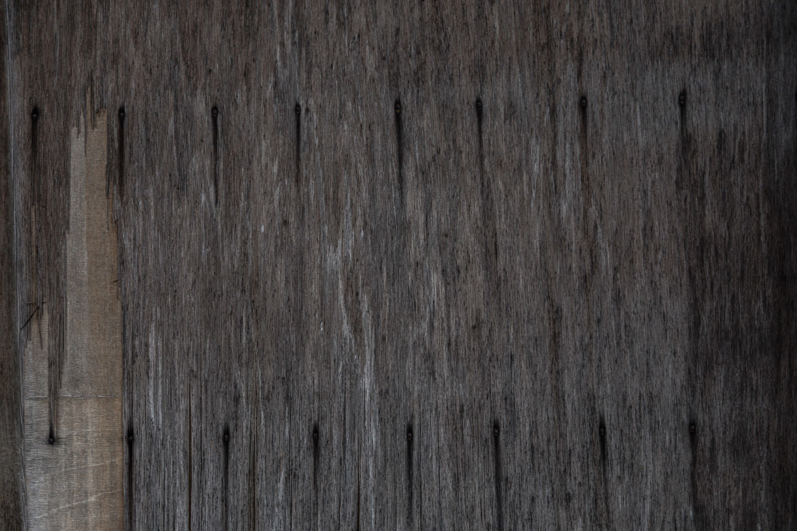 風化してグレーに変色した古い木材の板が縦に並んだテクスチャー