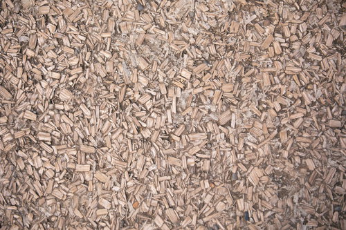 細かな木片（ウッドチップ）が踏み固められた茶色い地面のテクスチャー