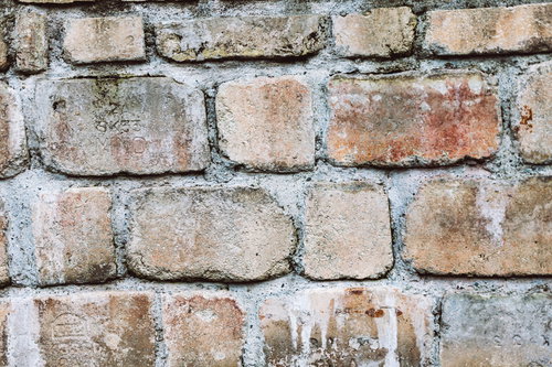 粗く塗り込んだ風化したレンガ壁のビンテージテクスチャー