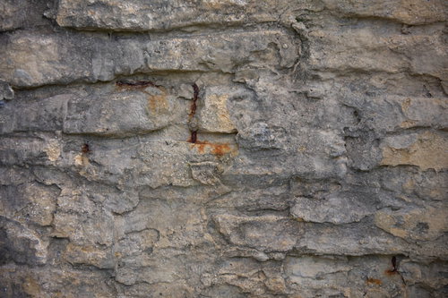 壁の内側から錆が漏れ出す石壁のテクスチャー