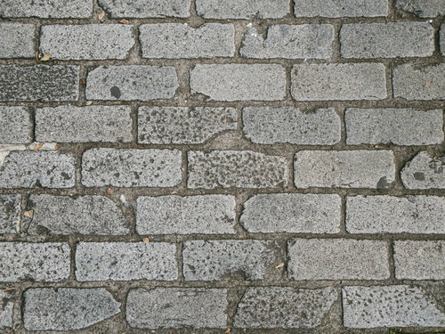 角の欠けたグレーのレンガ調タイルの床の質感テクスチャー