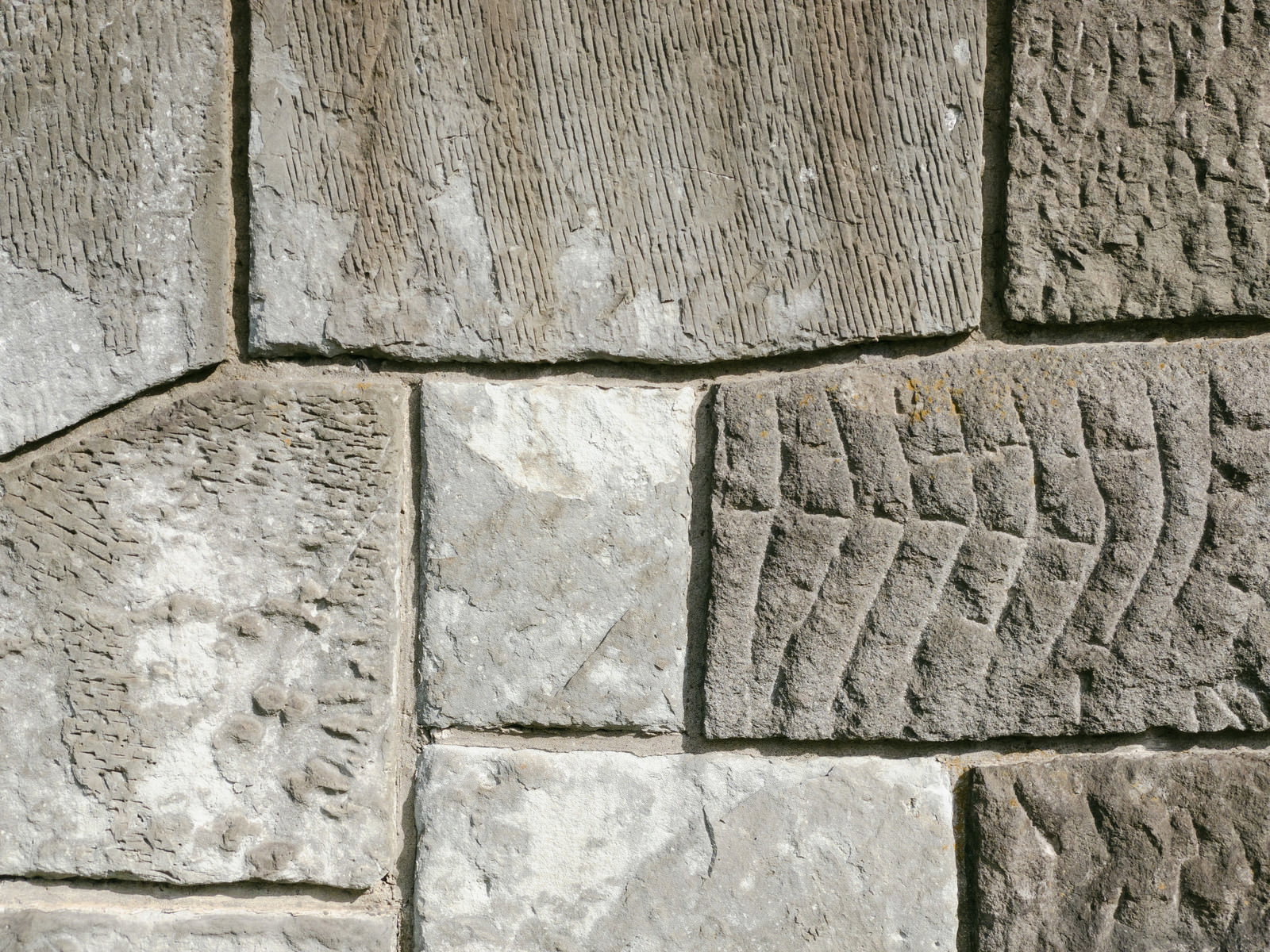 異なる模様の入ったグレー色のセメントタイルが組み合わさった壁面