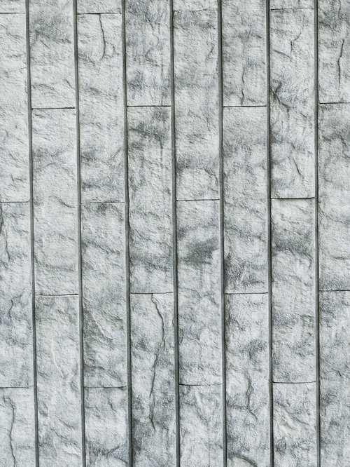 縦の目地が目立つグレーのタイルの壁