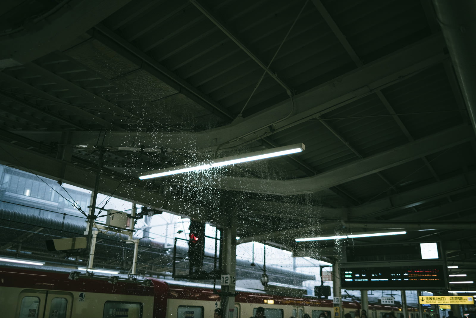 豪雨により駅のホーム内が水浸しになり、天井から雨水が漏れている様子