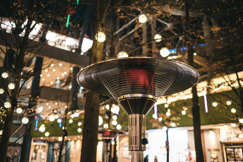 屋外に設置されたパラソルヒーターとイルミネーション