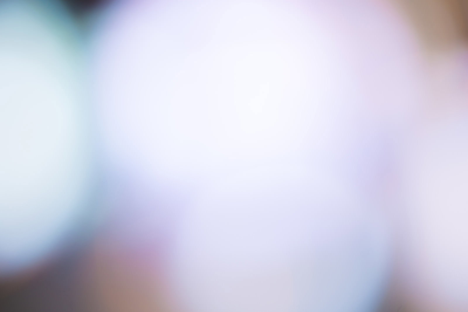 柔らかな暖色系の光がぼんやりと広がるピンボケした抽象的な背景