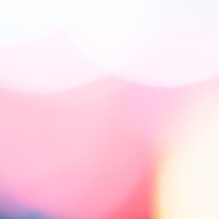 ピンクから白へのグラデーションが広がる暖色のボケた光の写真