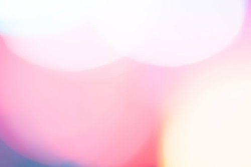 ピンクから白へのグラデーションが広がる暖色のボケた光