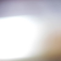 画面を横切る明るい光とボケのグラデーションの写真