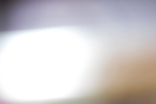 画面を横切る明るい光とボケのグラデーション