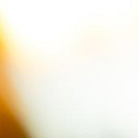 黄色からオレンジ色へ走る閃光と光の軌跡が広がる抽象的背景の写真