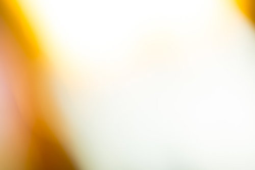 黄色からオレンジ色へ走る閃光と光の軌跡が広がる抽象的背景