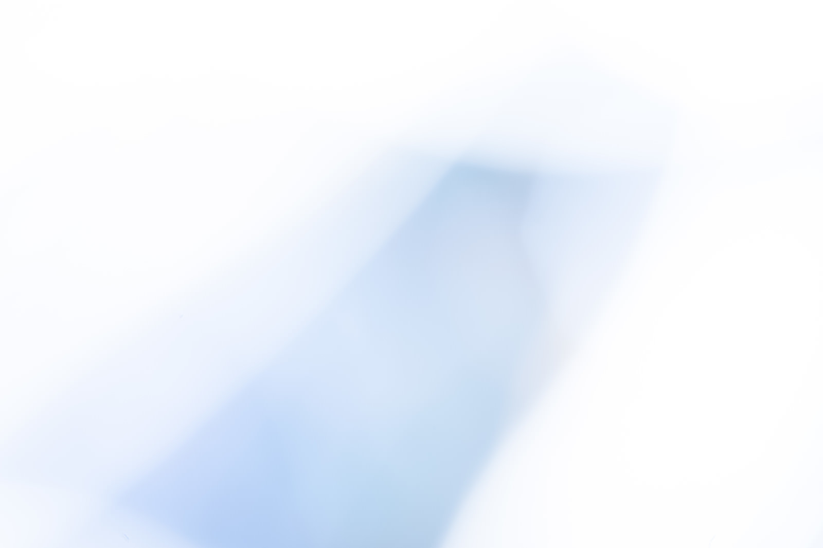 淡い青色の光がやわらかくぼけた抽象的な影の写真