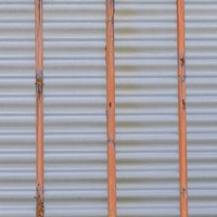 鉄棒で支えるオレンジ色のシャッター裏側の金属テクスチャの写真