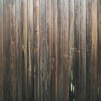 縦張りされた木板が規則正しく並ぶ板壁のテクスチャーの写真