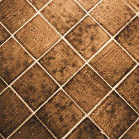ダイヤモンド状に配置された茶系の床タイルの写真