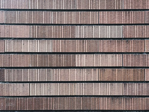 溝が刻み込まれた茶系の外壁材タイル