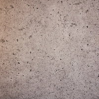 所々に細かい穴が残るコンクリート壁の表面の写真