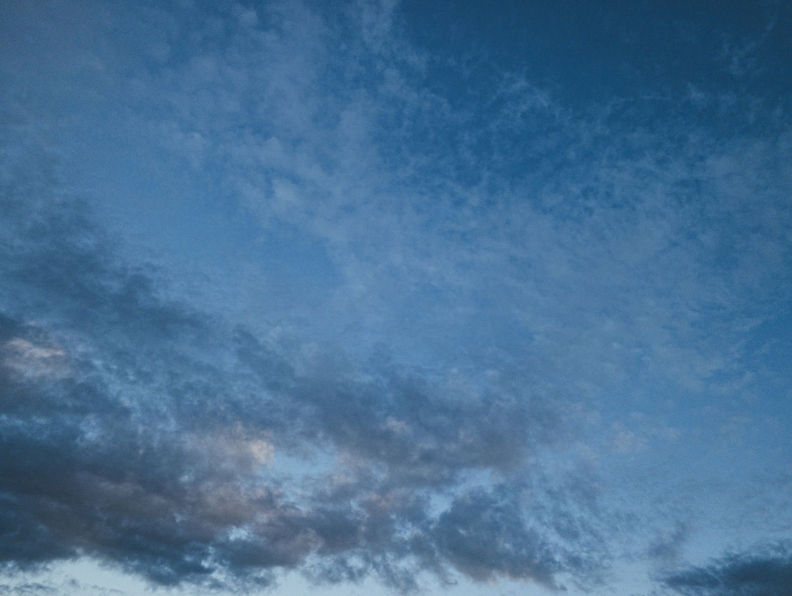 黒い雲と薄い雲が青空に混在している様子