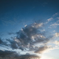 夕方の青空に立ち込める黒い雲の風景の写真