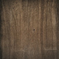 木目が入った板に刺さった黒いネジのテクスチャーの写真