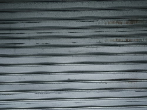 擦れたグレー金属シャッターのテクスチャー