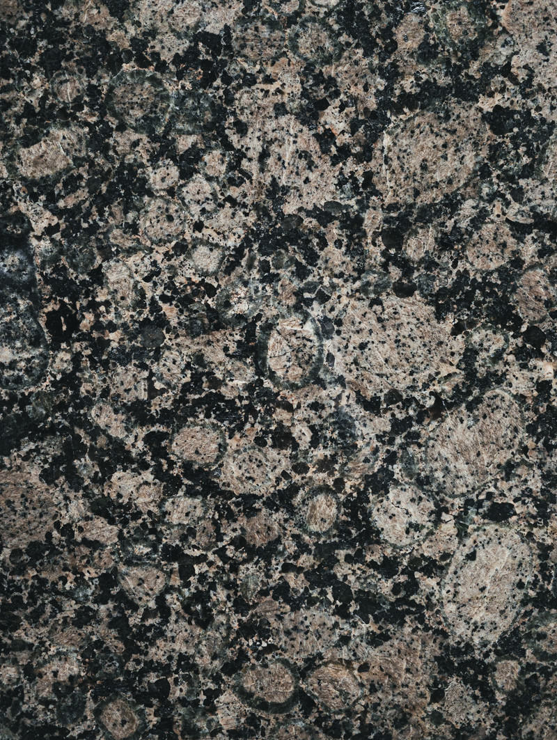 グレー基調で黒白の斑点が散らばる石材タイルの表面テクスチャー