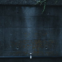 白い配管が付いたコンクリート壁のテクスチャーの写真