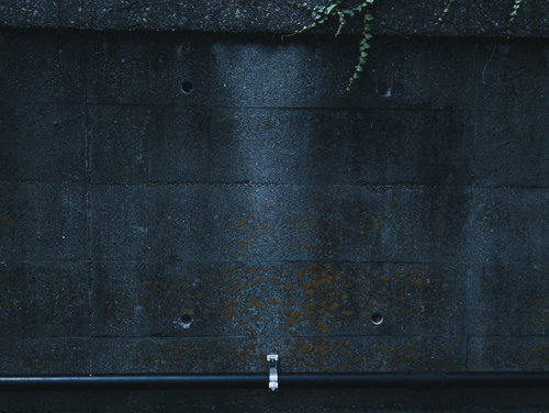 白い配管が付いたコンクリート壁のテクスチャー