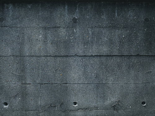 グレーのコンクリート壁に等間隔で配置された水抜き穴（テクスチャ）