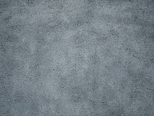 コンクリート壁の表面に付着したまだらなシミと汚れ