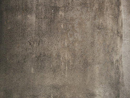 経年劣化でシミが一面に広がるコンクリート壁のテクスチャ