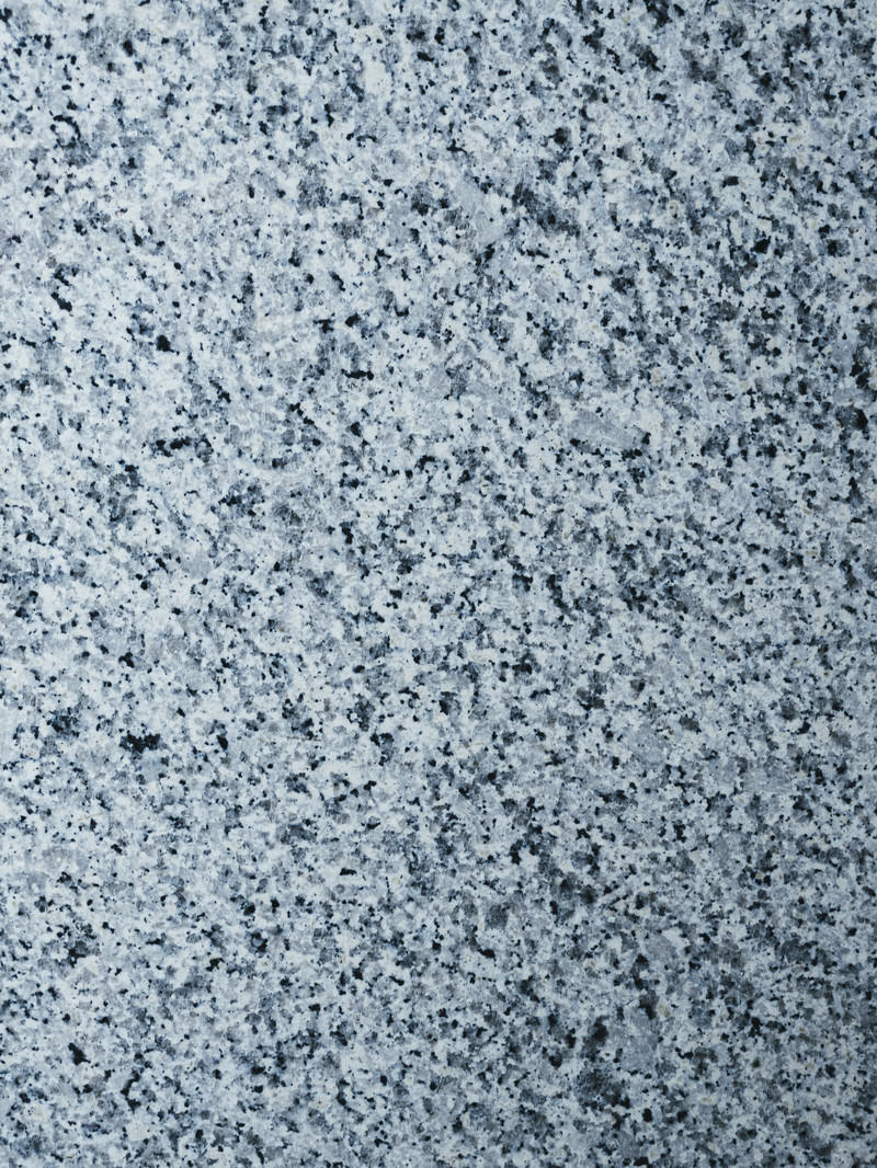 グレーの石材タイルの表面に細かい粒状の模様が均一に広がる