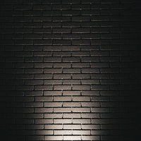 暖色系照明でライトアップしたレンガ調の外壁の写真