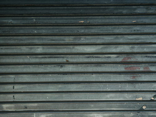 細かく傷の入った古いシャッター、経年劣化したテクスチャ