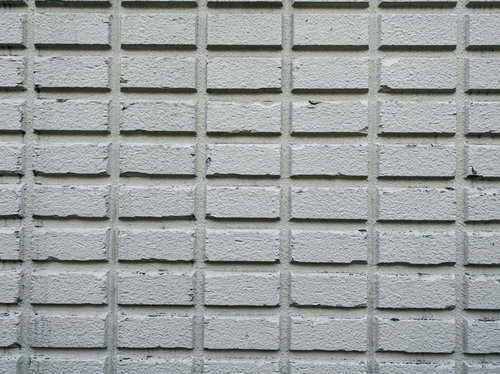 角のかけた灰色のデコボコタイル外壁