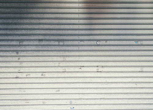 シール跡や汚れが残る金属製ガレージシャッター