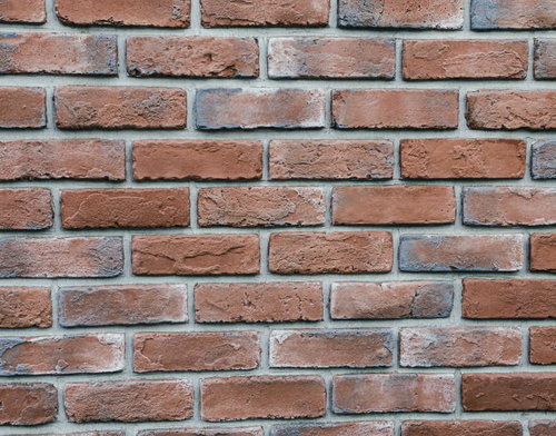 赤茶色に積み上げたレンガの壁のクローズアップテクスチャー