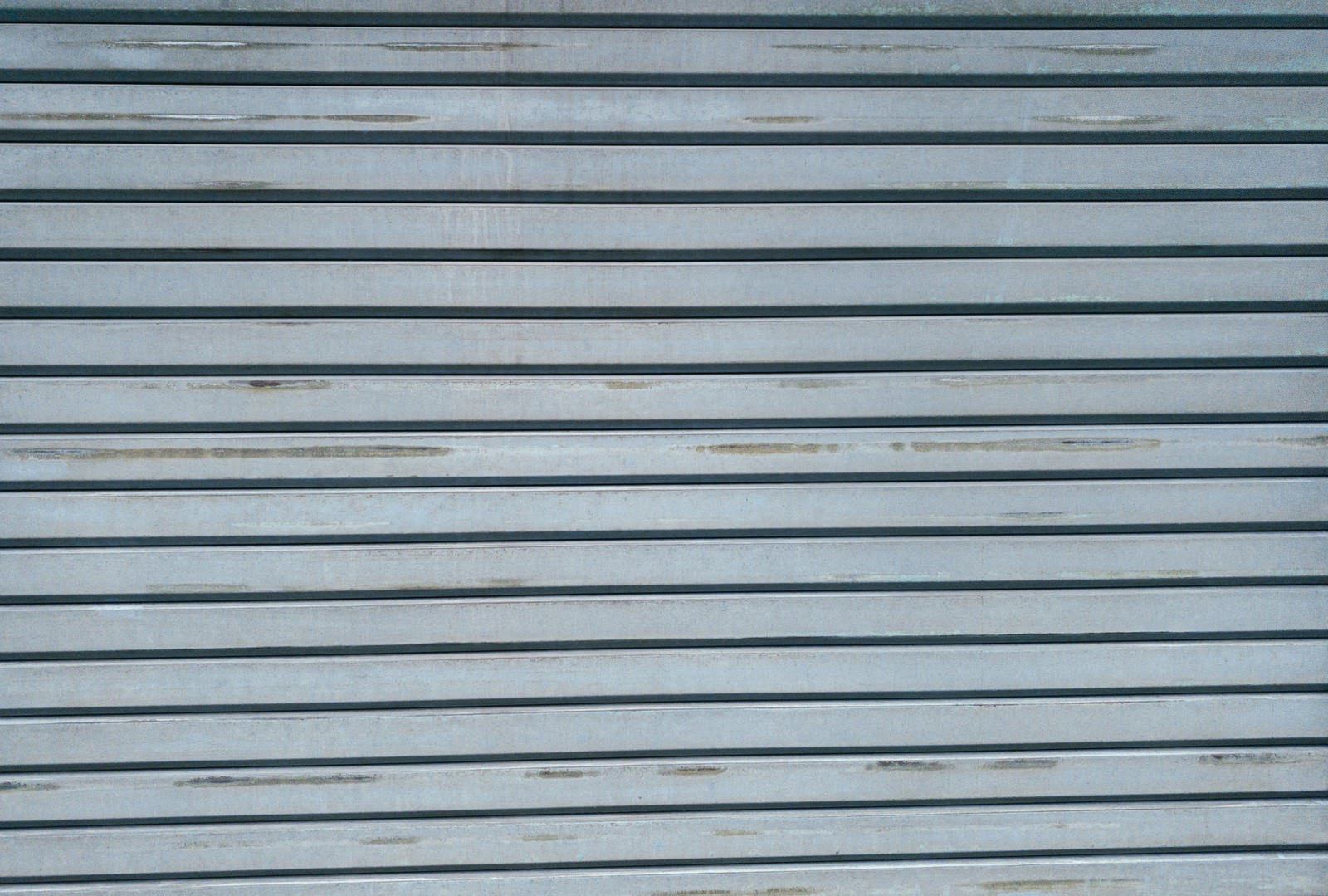 所々擦れや汚れのあるグレーの金属製シャッター