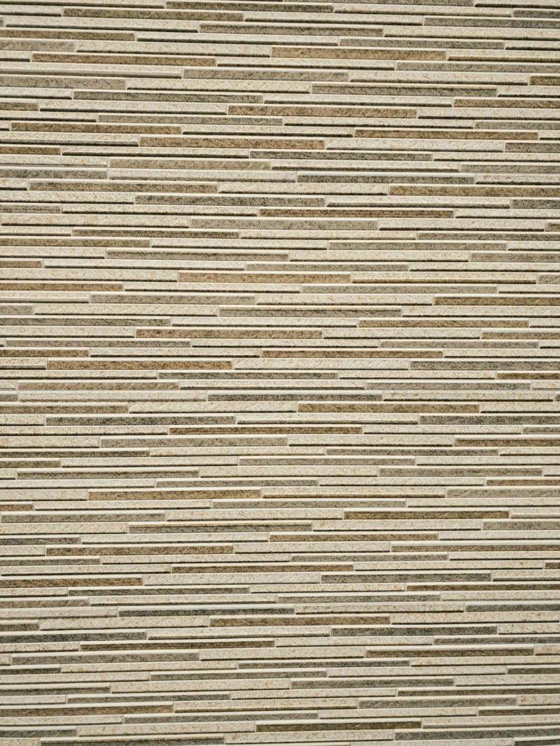 ベージュ色の細長いタイルが水平に並んだ外壁のテクスチャ