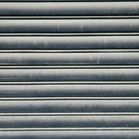 汚れが付いたグレーの金属シャッターの写真