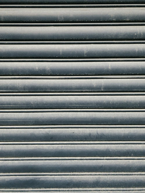 汚れが付いたグレーの金属シャッター