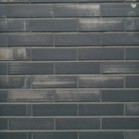 グレーの煉瓦タイルに残る擦れた跡と汚れ、風化による変色の写真