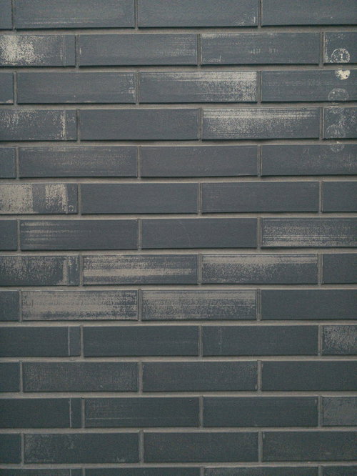 グレーの煉瓦タイルに残る擦れた跡と汚れ、風化による変色