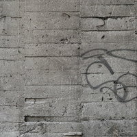 落書きが刻まれたグレーのコンクリート壁の擁壁テクスチャの写真