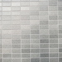 光が反射するグレーのタイル壁の建築外壁テクスチャーの写真