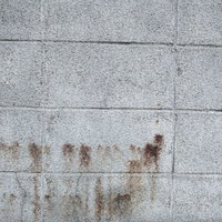 茶色い染みが付いたコンクリートブロック塀の写真