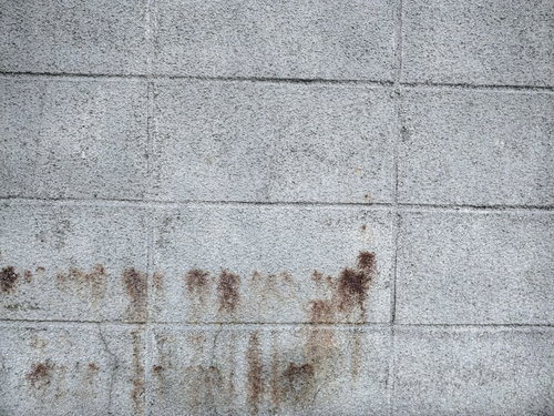 茶色い染みが付いたコンクリートブロック塀