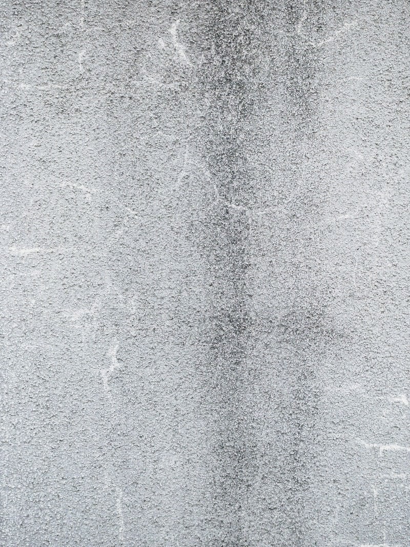 ひび割れが入ったグレーのモルタル外壁のテクスチャ