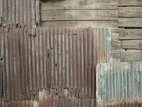 継ぎ接ぎされたボロボロの波板と錆びた金属